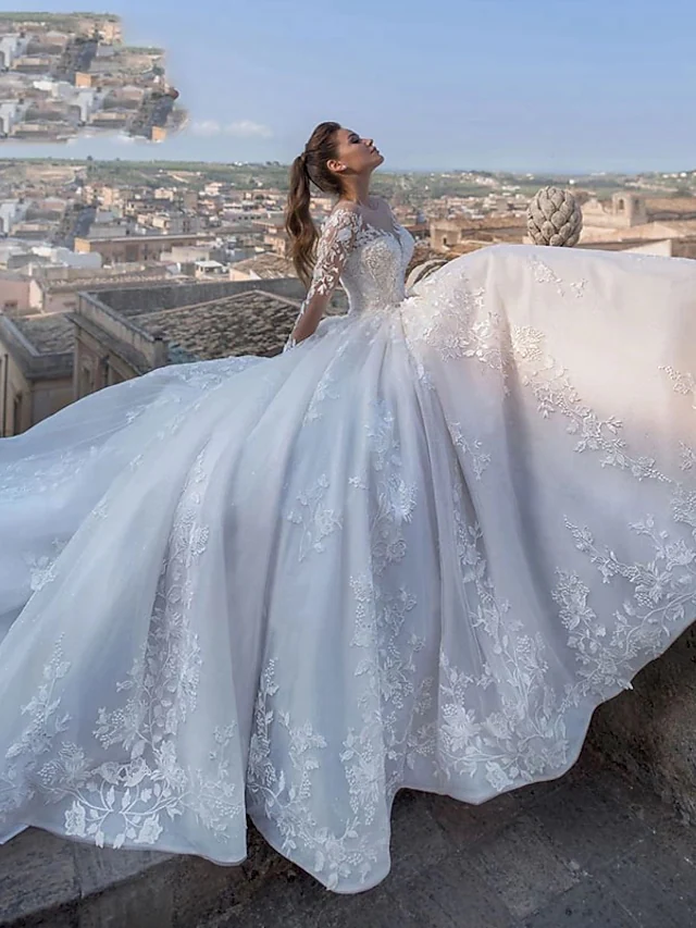 Detailed view of the lace and tulle fabric with appliques on the chapel train of the wedding dress.