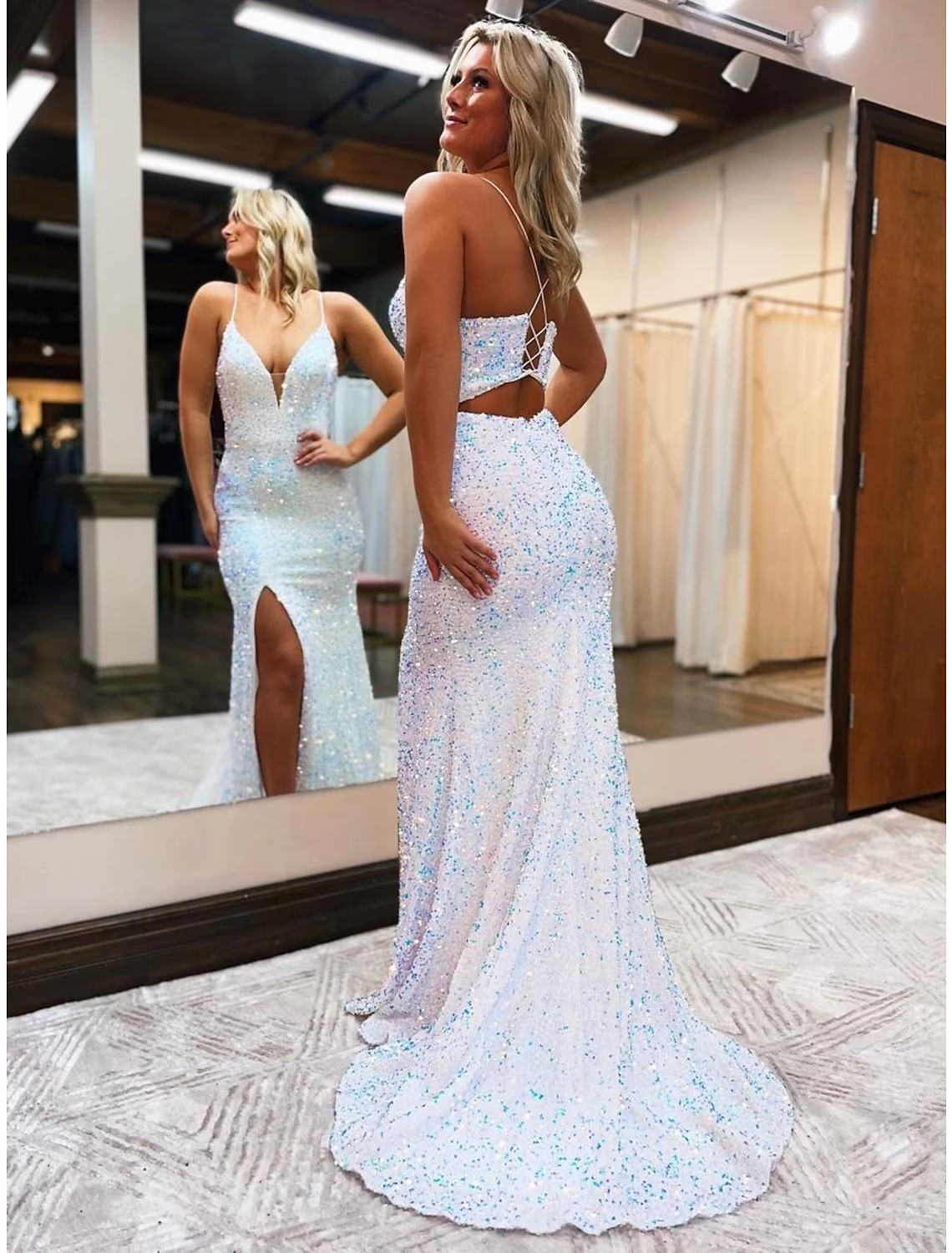 Side view of a woman wearing the sequined mermaid trumpet prom dress, highlighting the backless design and court train.