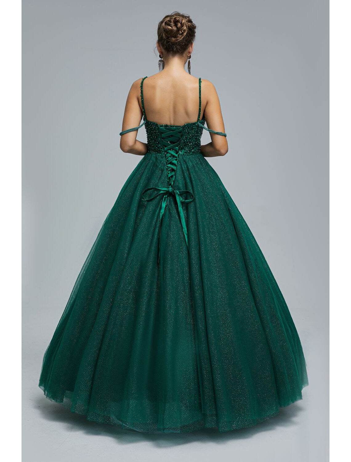Back view of floor-length tulle ball gown with sequin and pearl details.