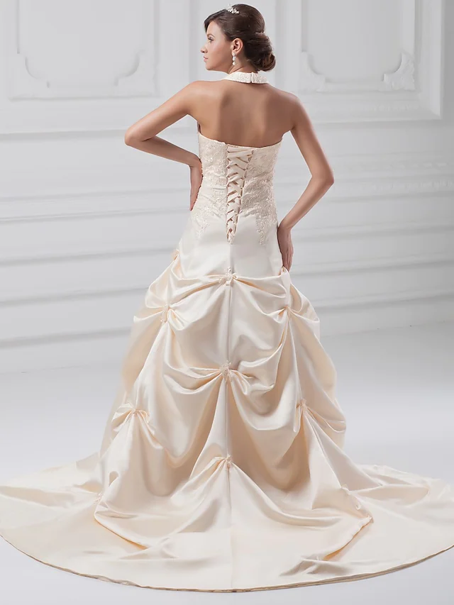 Close-up of lace, beading, and applique details on a wedding dress.