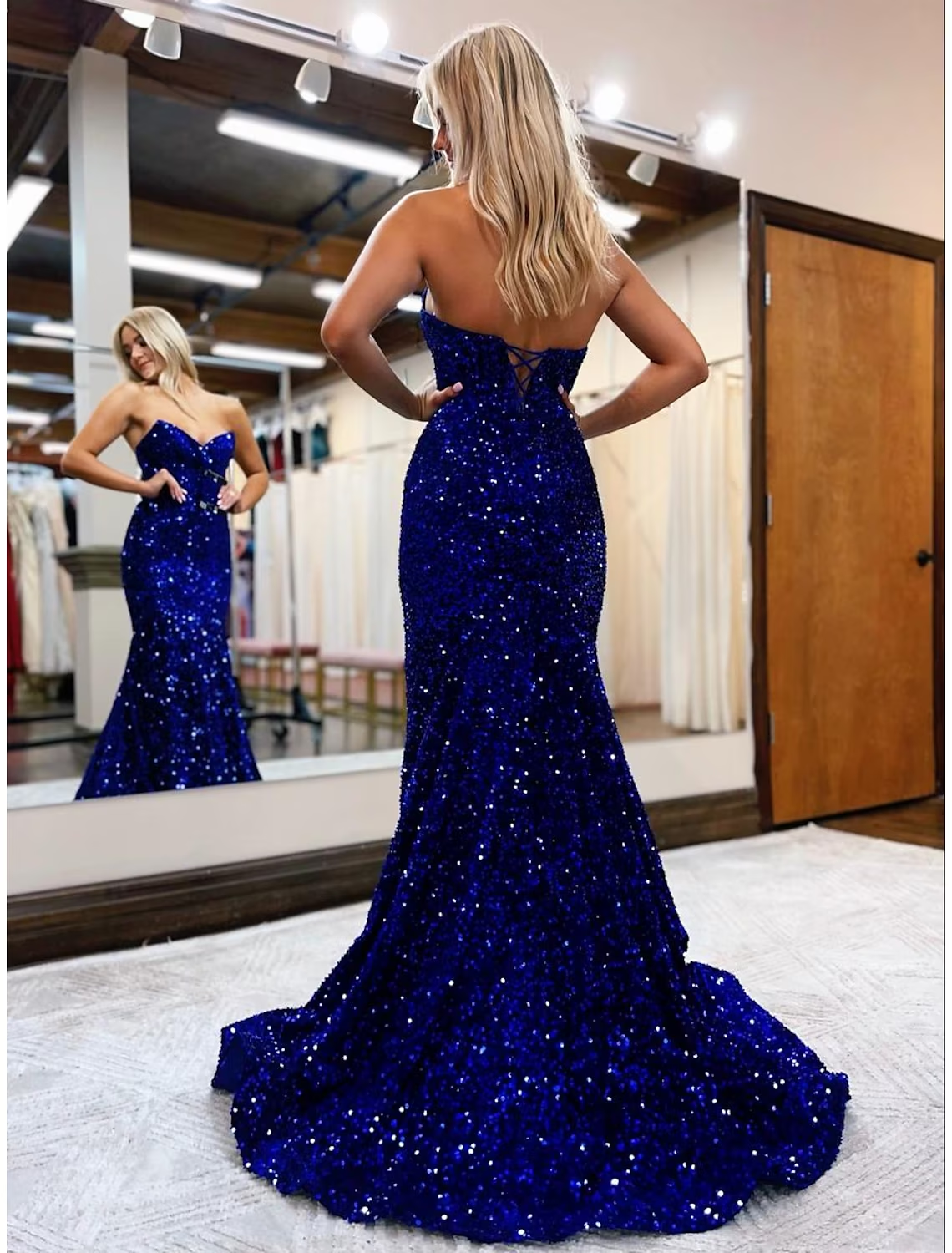 Side view of the blue sequined mermaid trumpet prom dress, showing the fitted silhouette and flowing train.