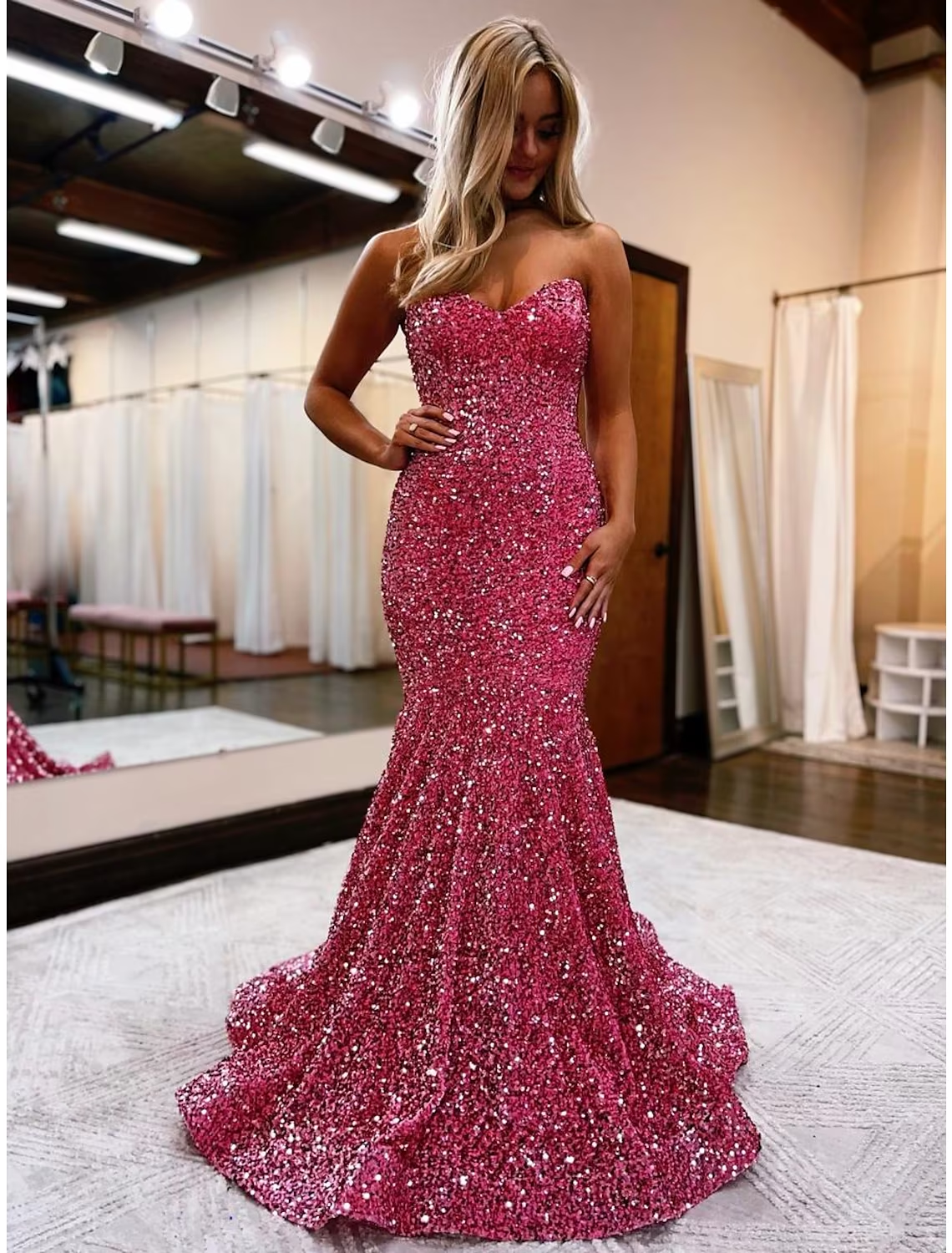 Back view of the blue sequined prom dress, highlighting the backless design and sweep train.