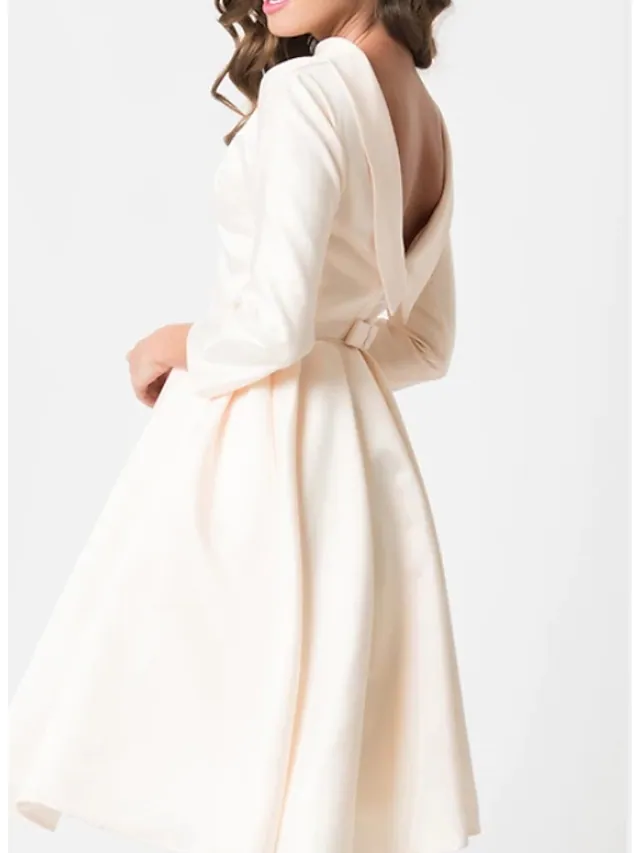 Back view of the knee-length white A-line wedding dress, showcasing its silhouette.