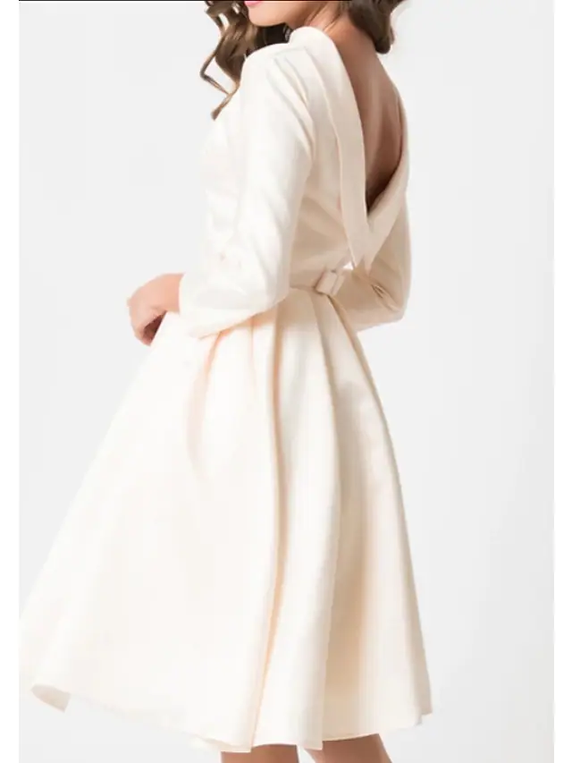 Side view of the vintage-inspired white wedding dress with a jewel neck and draping detail.