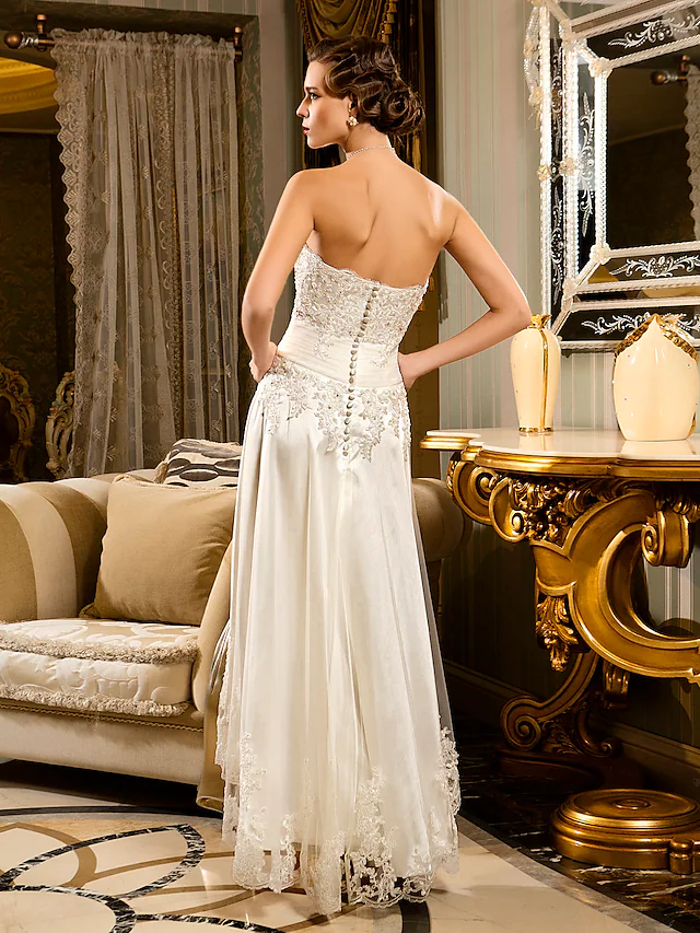 Side view of an A-Line bridal gown with asymmetrical design.
