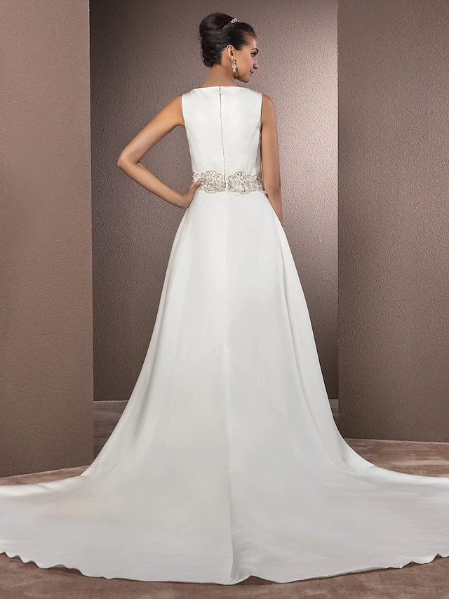 Side view of bride in satin wedding dress with cathedral train.